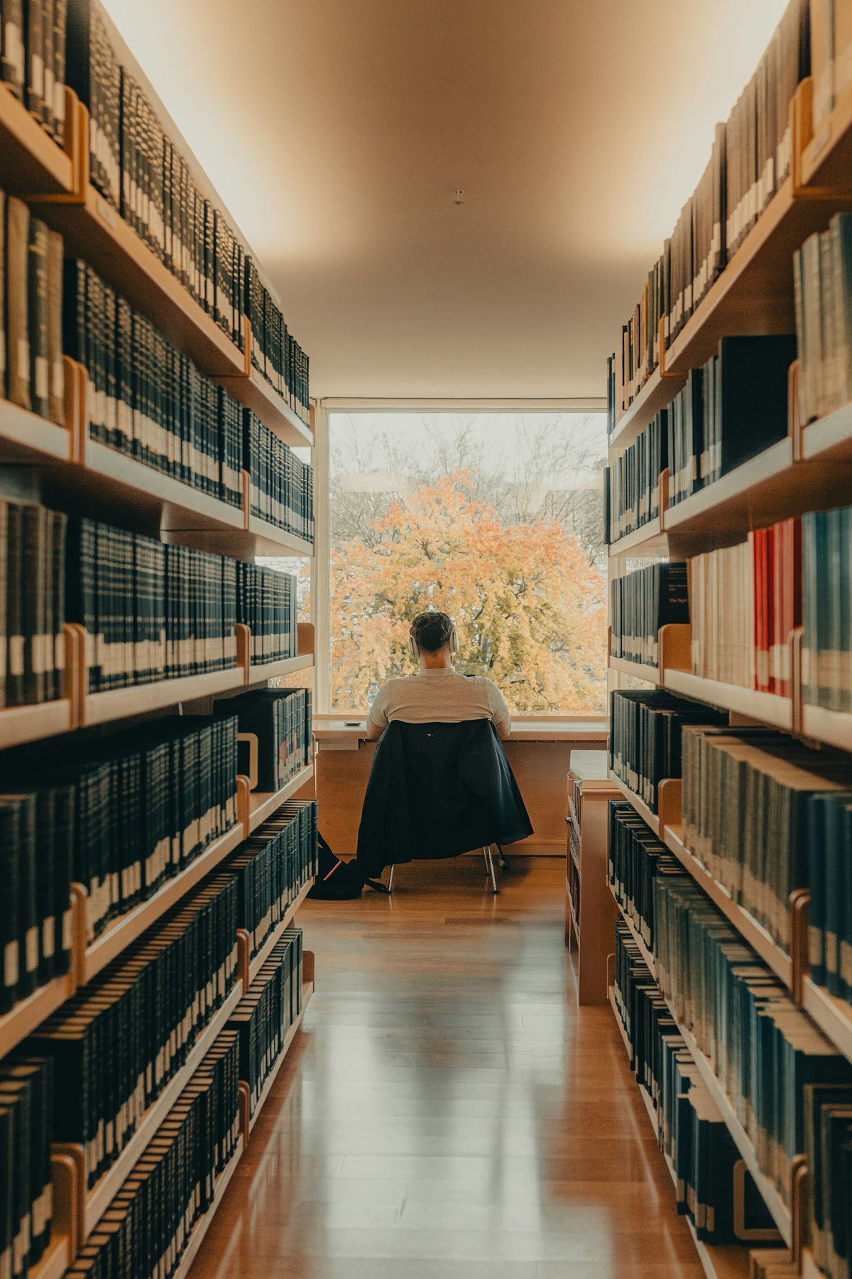 Étudiant révisant des documents financiers à une table de bibliothèque